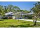 A charming single-story home with a well-manicured lawn, a cozy front porch, and mature trees at 1832 Magnolia Ave, Winter Park, FL 32789
