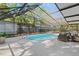 Enclosed pool area with patio furniture, lush landscaping, and bright blue skies at 1832 Magnolia Ave, Winter Park, FL 32789