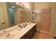 Bright bathroom with double sinks, a large mirror, and a glass-enclosed shower at 1862 Great Falls Way, Orlando, FL 32824