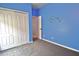 A blue bedroom with a closet and doorway at 1862 Great Falls Way, Orlando, FL 32824