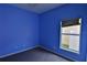 A vibrant blue bedroom featuring a window that overlooks the backyard at 1862 Great Falls Way, Orlando, FL 32824