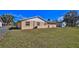 Backyard featuring grass, a fence, and the exterior of the home with access door at 209 Georgetowne Blvd, Daytona Beach, FL 32119