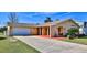 Charming single-story home featuring a two-car garage, stucco siding and a well-manicured lawn at 209 Georgetowne Blvd, Daytona Beach, FL 32119