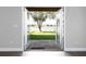 View of backyard through open french doors, showcasing a stone patio and green grass at 2934 Wild Tamarind Blvd, Orlando, FL 32828