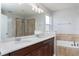 This bathroom features double sinks, a separate shower, and a soaking tub with tiled accents at 2934 Wild Tamarind Blvd, Orlando, FL 32828