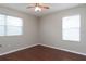 Bedroom with wood-look floors, light gray walls, and natural light from the two large windows at 2934 Wild Tamarind Blvd, Orlando, FL 32828