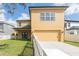 Charming two-story home with a yellow exterior, two car garage, and a white picket fence at 2934 Wild Tamarind Blvd, Orlando, FL 32828
