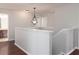 Upstairs hallway with wood flooring, white trim, and a decorative light fixture at 2934 Wild Tamarind Blvd, Orlando, FL 32828