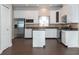 Bright kitchen featuring stainless steel refrigerator, white cabinetry, and a functional center island at 2934 Wild Tamarind Blvd, Orlando, FL 32828
