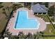 Aerial view of a community pool featuring plenty of lounge chairs, manicured landscaping, and clubhouse at 2934 Wild Tamarind Blvd, Orlando, FL 32828