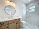 Contemporary bathroom featuring wood cabinets, a round mirror, and a glass shower at 3206 Harrison Ave, Orlando, FL 32804