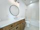 Charming bathroom with wood cabinet, white countertop, round mirror, and tiled shower/tub combo at 3206 Harrison Ave, Orlando, FL 32804