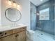 Stylish bathroom features wood cabinets, a sleek round mirror, and tiled glass shower at 3206 Harrison Ave, Orlando, FL 32804