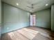 Spacious bedroom with paneled walls, wood floors, and a view to hallway at 3206 Harrison Ave, Orlando, FL 32804