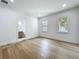 Light-filled bedroom features hardwood floors and easy access to an ensuite bathroom with wood cabinets at 3206 Harrison Ave, Orlando, FL 32804