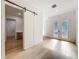 Bright foyer featuring stylish barn door, frosted glass doors, and hardwood flooring at 3206 Harrison Ave, Orlando, FL 32804