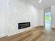 Bright living room with light floors, a tiled accent wall, and a modern fireplace at 3206 Harrison Ave, Orlando, FL 32804