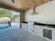 The outdoor kitchen offers black granite countertops, stainless appliances, and a view of the screened in pool at 3206 Harrison Ave, Orlando, FL 32804