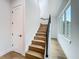 Modern staircase with wooden steps and a black railing next to a bright window at 3206 Harrison Ave, Orlando, FL 32804
