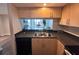 Efficient kitchen design with dark countertops, stainless steel sink and light wood cabinets at 322 E Central Blvd # 1805, Orlando, FL 32801