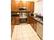 Modern kitchen with stainless steel appliances, granite countertops, and cherry wood cabinets at 346 Canyon Stone Cir, Lake Mary, FL 32746