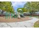 Community playground with slides, swings, and play structures surrounded by lush greenery and trees at 346 Canyon Stone Cir, Lake Mary, FL 32746