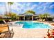Community swimming pool surrounded by lounge chairs, landscaped foliage, and beautiful palm trees at 346 Canyon Stone Cir, Lake Mary, FL 32746