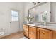 Bathroom vanity with wood cabinets, marble countertops, a large mirror, and bright lighting at 3603 Westover Cir, Leesburg, FL 34748