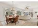 Dining area adjacent to living room features a chandelier and views of the screened pool at 3603 Westover Cir, Leesburg, FL 34748