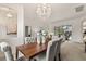 Chic dining room with a dark wood table, gray upholstered chairs, and a modern chandelier, perfect for elegant dinners at 3603 Westover Cir, Leesburg, FL 34748