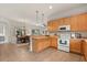 Bright kitchen with wooden cabinets, a breakfast bar and an open view into the dining area at 3603 Westover Cir, Leesburg, FL 34748