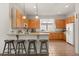 Bright kitchen with wooden cabinets, a breakfast bar, and views of the backyard at 3603 Westover Cir, Leesburg, FL 34748