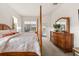 Bright main bedroom featuring a four poster bed, neutral colors, and a view of the pool at 3603 Westover Cir, Leesburg, FL 34748