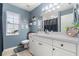 A well-lit bathroom with blue walls, a white vanity, decorative elements, and a toilet at 37 Spring Ln, Haines City, FL 33844