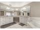 Spacious bathroom featuring dual sinks, large mirrors, white cabinets, and a luxurious soaking tub at 37 Spring Ln, Haines City, FL 33844
