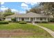 Charming single-story home with a well-manicured lawn, white columns, and a welcoming front porch at 37 Spring Ln, Haines City, FL 33844