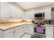 Kitchen featuring white cabinets, tile backsplash, stainless steel range, and light countertops at 37 Spring Ln, Haines City, FL 33844