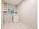 Laundry room with a washing machine, built-in shelving, and tile flooring at 420 1St St, Ocoee, FL 34761