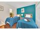 Comfortable bedroom with twin beds, wood floors and colorful accent wall at 438 Miramar Ave, Davenport, FL 33897