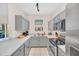 Well-lit kitchen with stainless steel appliances, gray cabinetry, and tiled flooring at 438 Miramar Ave, Davenport, FL 33897