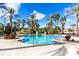 Beautiful community pool with lounge chairs surrounded by swaying palm trees at 438 Miramar Ave, Davenport, FL 33897