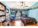 Blue bedroom features wood floors, a ceiling fan, and unique book decor at 442 Jessamine Dr, Davenport, FL 33837