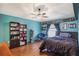 Blue bedroom features wood floors, a ceiling fan, and unique book decor at 442 Jessamine Dr, Davenport, FL 33837