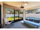 The screened lanai is equipped with a ceiling fan, futon, chair, and backyard views at 442 Jessamine Dr, Davenport, FL 33837