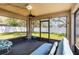 The screened lanai is equipped with a ceiling fan, futon, chair, and backyard views at 442 Jessamine Dr, Davenport, FL 33837