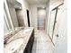 A bright bathroom features a double sink vanity with a granite countertop, ceramic tile flooring and a glass enclosed shower at 464 Patricia Alford Dr, Haines City, FL 33844