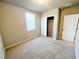 Neutral bedroom featuring plush carpeting, a large window and a closet with open doors at 464 Patricia Alford Dr, Haines City, FL 33844