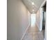 Long hallway with neutral paint, tile floors, and recessed lighting at 464 Patricia Alford Dr, Haines City, FL 33844