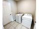 A tidy laundry room features tiled floors and a white washer and dryer set at 464 Patricia Alford Dr, Haines City, FL 33844