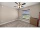 Neutral bedroom with carpet, ceiling fan, a window with blinds, and an electrical outlet at 4730 Sw 138Th Ln, Ocala, FL 34473